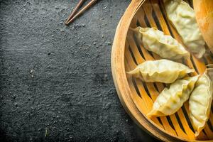 Fragrant Chinese gedza dumplings in a bamboo steamer. photo