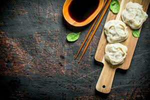 Dumplings manta on a cutting Board with soy sauce. photo