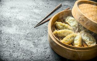 Hot gedza dumplings in a bamboo steamer. photo