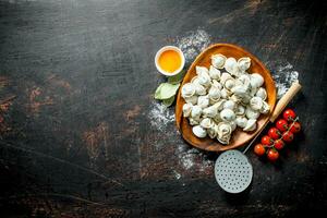 Raw dumpling on a plate with egg yolk and cherry tomatoes. photo