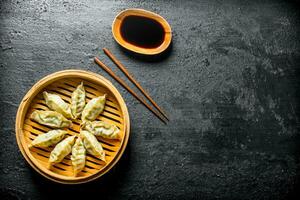 Fragrant Chinese gedza dumplings in a bamboo steamer. photo