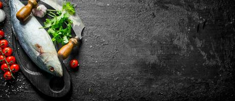 Fresh raw fish with knife, parsley and garlic. photo