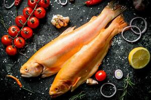 Raw fish trout with chili pepper, cherry tomatoes and lemon. photo