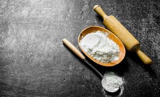 Flour with a ladle and rolling pin. photo