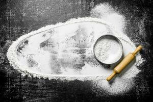 Flour with a sieve and a rolling pin. photo