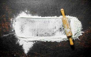 Wheat flour with rolling pin. photo