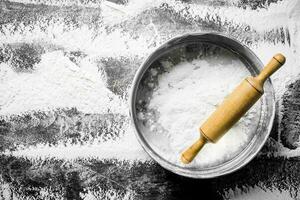 Flour with a sieve and a rolling pin. photo