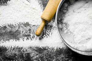 Flour with a sieve and a rolling pin. photo