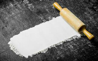 Flour with a wooden rolling pin. photo