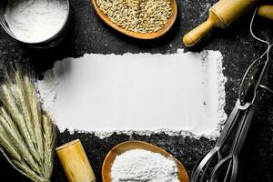 Wheat flour with grain, spikelets, rolling pin and mixer. photo