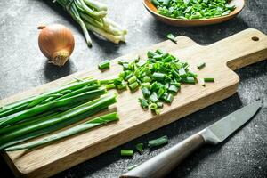 Green onion sliced on a cutting Board with onion. photo