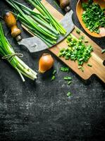 Green and onions with a large knife. photo