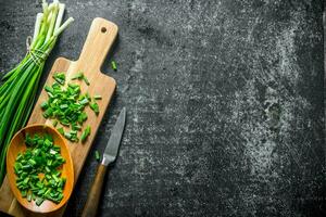 Chopped green onion on a wooden cutting Board. photo