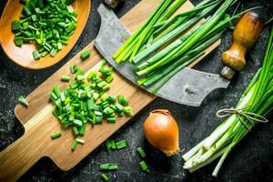 Green and onions with a large knife. photo