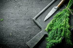 Fresh dill on a cutting Board with a knife. photo