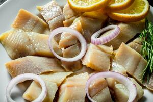 Salted herring fillet with onion rings. photo