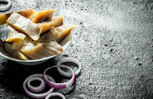 Sliced fillet of salted herring with onion rings. photo