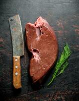 Raw liver with knife and dill. photo