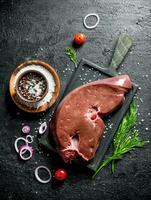 Raw liver with spices, dill and onion rings. photo