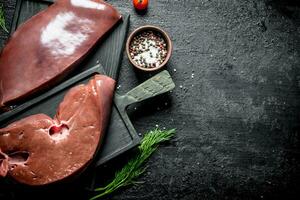 Raw liver with dill and spices in bowl. photo