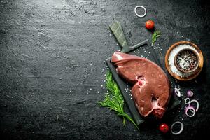 Raw liver with spices, dill and onion rings. photo