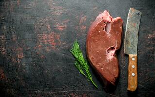 Raw liver with knife and dill. photo