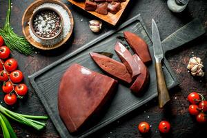 Sliced raw liver with tomatoes, herbs and spices. photo