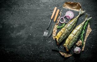 delicioso ahumado caballa pescado con anillos de Fresco cebollas y ajo clavos de olor. foto