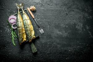 Fragrant smoked mackerel with chopped onions, a sprig of rosemary and garlic. photo