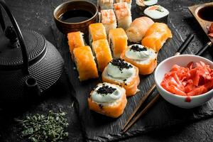 Sushi rolls with salmon and shrimp on a stone stand. photo