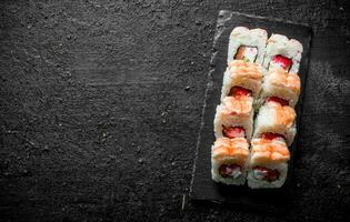 Traditional sushi rolls with shrimp on a stone Board. photo