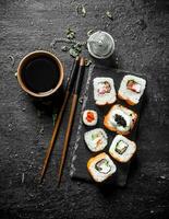 Various Japanese rolls with soy sauce and chopsticks. photo