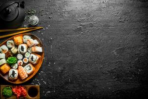 Fresh sushi and rolls with sauces and green tea. photo