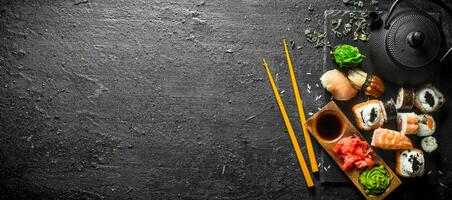 Sushi rollos con camarón y salmón en un Roca tablero. foto