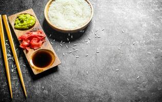 Soy sauce, ginger and wasabi in a wooden stand. photo