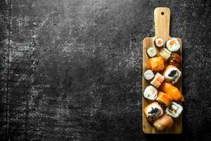 Freshly cooked sushi rolls on a cutting Board. photo