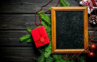 Photo frame with Christmas decorations and fir branches.