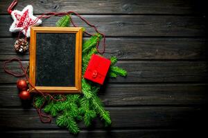 Photo frame with Christmas decorations and fir branches.