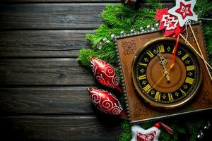 retro reloj con Navidad decoraciones y verde abeto sucursales. foto