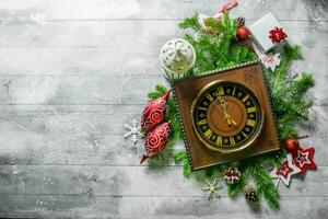 antiguo reloj con Navidad decoraciones y abeto sucursales. foto