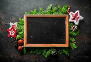 Photo frame with Christmas decorations and fir branches.