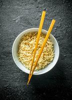 Instant noodles in bowl with chopsticks. photo