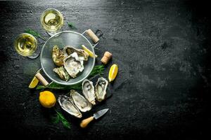 Raw oysters in a colander with white wine, lemon and dill. photo