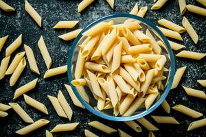 Pasta background. Dry pasta in a bowl. photo