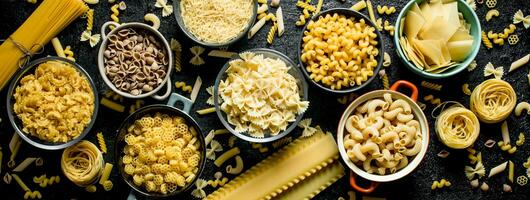 Different types of dry pasta in bowls. photo