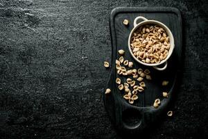 Conchiglle dry pasta in a bowl on a cutting Board. photo