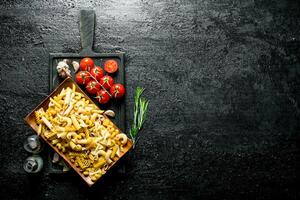 Different kinds of raw paste on a plate with tomatoes, garlic and rosemary. photo