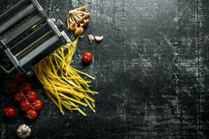 Machine for cooking homemade pasta with tomatoes and mushrooms. photo