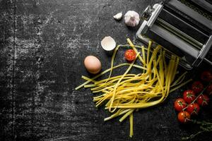 Preparation of homemade raw pasta with tomatoes and thyme. photo