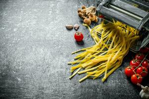 Machine for cooking homemade pasta with tomatoes and mushrooms. photo